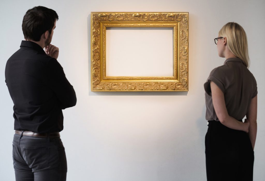 Man and woman looking at empty picture frame