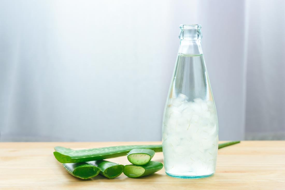 aloe-vera-juice-in-glass-bottle-next-to-aloe-vera-leaves-cut-and-piled-up